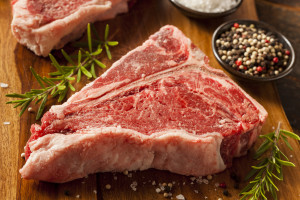 Thick Raw T-Bone Steak with Seasoning and Rosemary