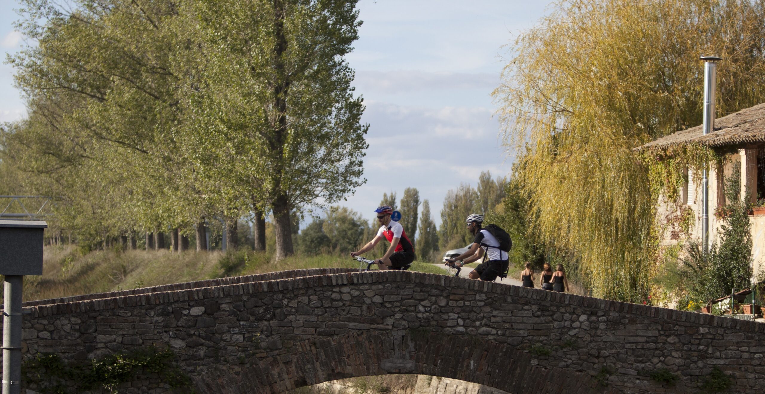 Ponte di pietra con ciclisti lungo la ciclovia Assisi - Spoleto.