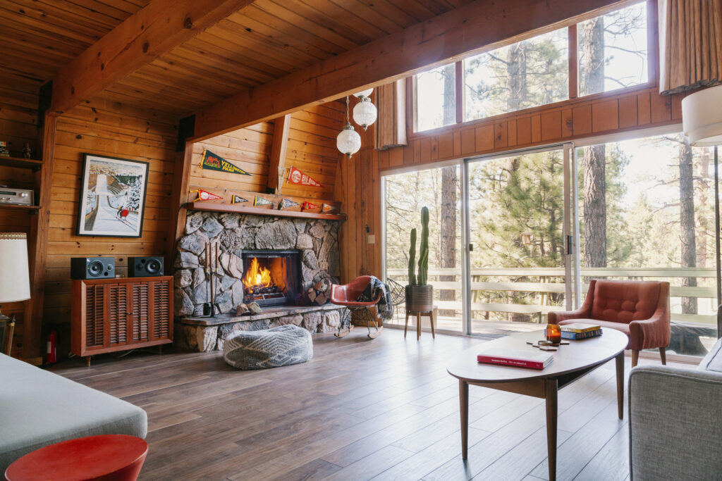 Interno casa in legno con camino. Fonte Airbnb