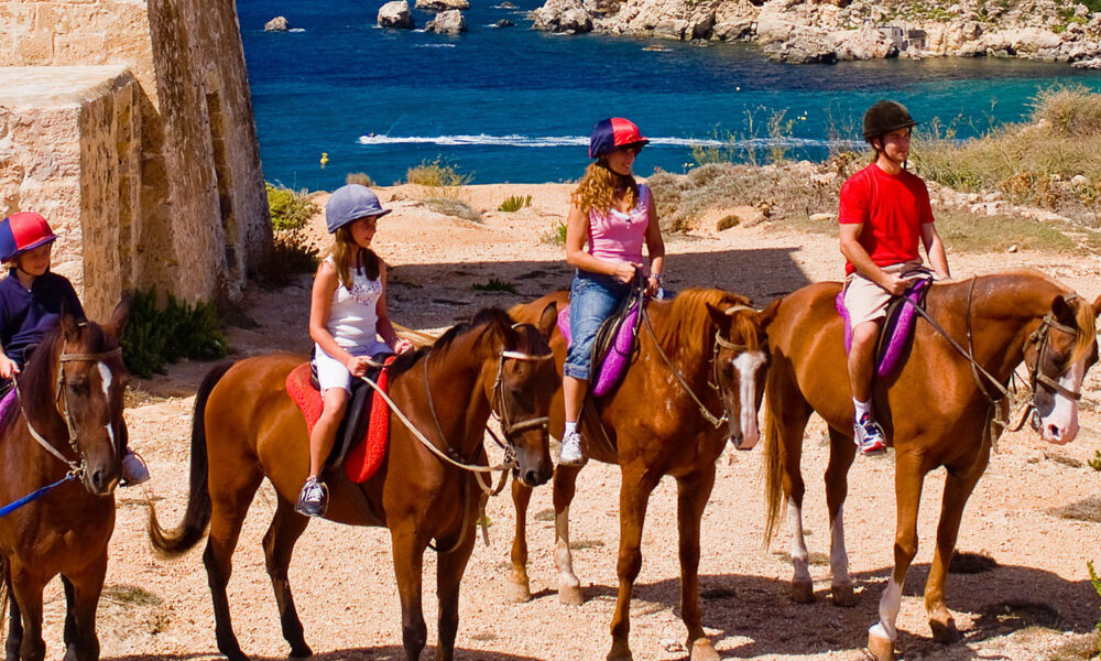 Equitazione a Malta: famiglia in gita a cavallo. Via Visit Malta.